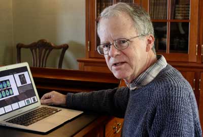 Dr. Daniel Gibbs at home, showing brain scan images on his computer.